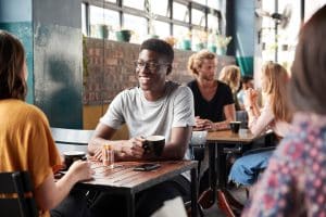 couple sitting at table in busy coffee shop talking